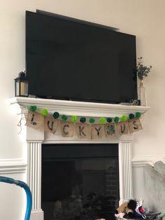 a tv mounted above a fireplace in a living room with decorations on the mantel