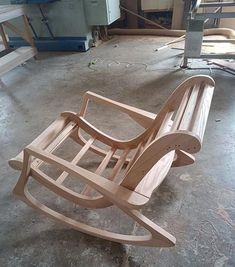 a wooden rocking chair sitting on top of a cement floor