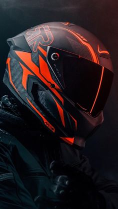 a person wearing a motorcycle helmet and jacket with an orange glow on it's face