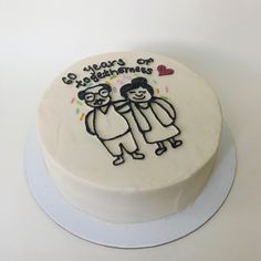 a white cake decorated with an image of two people holding each other's hands