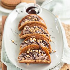 there are several pieces of bread on the plate with chocolate sauce and sprinkles