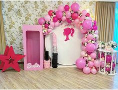 a barbie themed birthday party with balloons and pink decorations on the wall, including a balloon arch