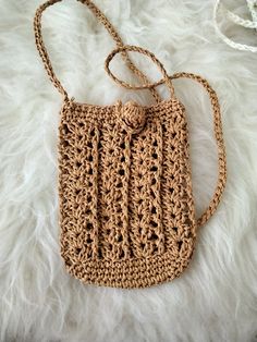 a crocheted purse sitting on top of a white blanket