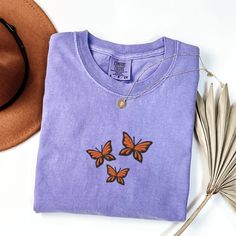 Comfort Colors Butterflies T-Shirt, Embroidered Butterflies Shirt, Cute Butterfly Shirt, Embroidered Insect T-shirt, Custom Butterfly Shirt This embroidered butterflies shirt is everything. Perfect to wear to show your love for butterflies! Please let me know if you are interested in a size 4X, I have certain size and color options available! ✨ 100% Cotton ✨ Pre-shrunk ✨ Relaxed fit Care: Machine wash: warm (max 40C or 105F) Tumble dry: low Do not iron directly on the design REFUNDS AND EXCHANGE Spring Crew Neck T-shirt With Butterfly Embroidery, Spring Butterfly Embroidered Crew Neck T-shirt, Short Sleeve Cotton Tops With Butterfly Embroidery, Casual Purple Tops With Embroidered Graphics, Embroidered Butterflies, Butterfly Shirt, Butterfly Shirts, Embroidered Butterfly, Cute Butterfly