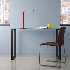 a desk with a chair and a lamp on it