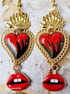 Beautiful and modern hand-painted sacred heart earrings, in Black and red, adorned with red lips, are protected with several layers of high-quality jewelry varnish, improving the quality and durability of the earrings. These hand-painted sacred heart earrings are unique and very beautiful, the ideal gift because they combine with any outfit both day and night, they will enhance the beauty and you will surely attract attention due to the unique and artisanal design, the Ideal gift for the Day of Mothers, weddings and holidays. Features/ Product info Note: The earrings in stock have some differences because they are hand painted. -The Main Material: Zinc Alloy (Gold) -Color: Black and red -Small: 1 in  (Please see the photos, this design comes in two sizes.) - Earrings: 3.25 in Including hoo Quirky Red Jewelry For Gifts, Red Heart-shaped Hand Painted Jewelry, Hand-painted Red Jewelry For Valentine's Day, Handmade Heart-shaped Enamel Earrings, Hand Painted Red Jewelry For Valentine's Day, Unique Heart-shaped Earrings For Valentine's Day, Hand Painted Heart Earrings For Valentine's Day Gift, Handmade Enamel Jewelry For Valentine's Day, Hand Painted Dangle Heart Earrings As Gift