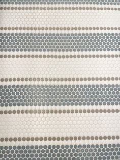 a close up view of a white and grey tile wall with circles on it's sides