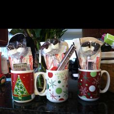 four coffee mugs decorated with candy canes and candies are sitting on a counter