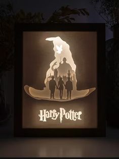 an illuminated shadow box with the silhouettes of harry potter