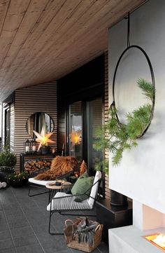 an outdoor living area with furniture and fireplace in the center, surrounded by greenery