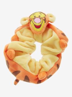 a yellow and orange stuffed animal with a smile on it's face in a scrunch