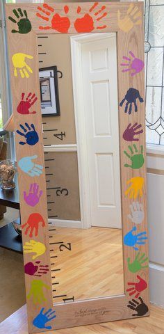 a wooden ruler with handprints on it sitting in front of a door and window