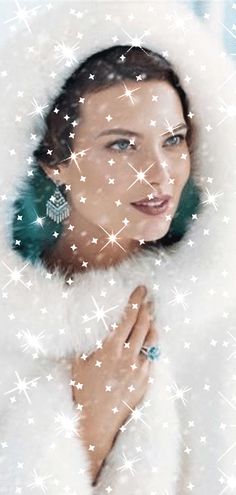 a woman wearing a fur coat with stars around her neck and ear rings on her left hand