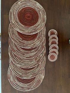 a stack of brown and white plates sitting on top of a wooden table next to a vase