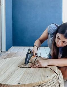 a woman is using an electric tool on a table