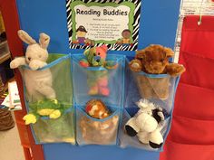 stuffed animals are sitting in plastic bins on the shelf next to a sign that says reading buddies