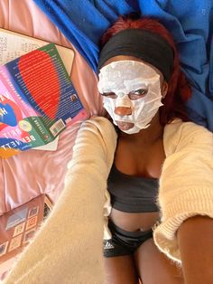 a woman laying on top of a bed wearing a face mask and bandage around her head