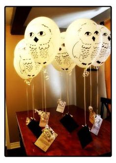 some white balloons with owls on them sitting on a table