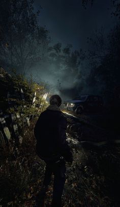 a man standing in the dark with his back turned to the camera and looking at something