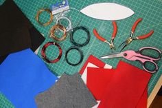 scissors, tape, and other crafting supplies laid out on a green cutting mat