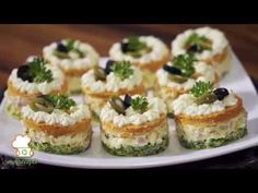 several small appetizers are arranged on a white plate with green garnishes