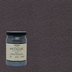 a jar of metallic paint sitting on top of a brown leather surface with a black lid