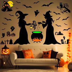 a living room decorated for halloween with witches and caulder wall decals on the walls