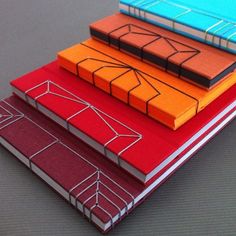 three notebooks are stacked on top of each other with different colored covers and lines