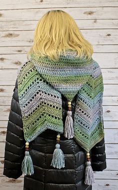 a crocheted jacket with tassels on it