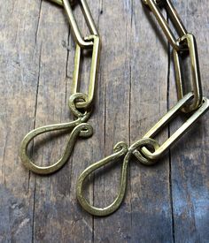 a close up of a metal chain on a wooden floor with two links attached to it