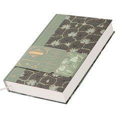 an open book with floral designs on the front and back cover, sitting on a white surface