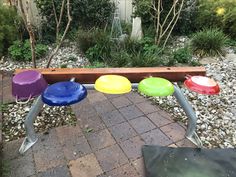 an outdoor play area with colorful plastic discs on it's sides and a bench in the background