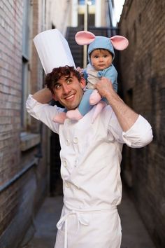 a man holding a baby in his arms while wearing a chef's hat and bunny ears