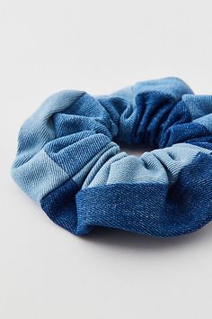 a blue scrunchy hair tie sitting on top of a white table