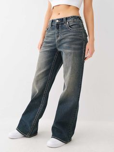 The Bobbi Big T Baggy Jean features a low-rise waist, zip fly, subtle fading, wide leg, and two-tone Big T stitching. Finished with horseshoe detailing on the back flap pockets and burnished hardware.    Style: 208451 Baggy True Religion Jeans, Fire Shoes, Baggy Jean, Dream Aesthetic, Painted Denim, Kids Denim, True Religion Jeans, Ripped Denim, Plus Size Jeans