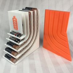 there are many batteries in the holder on the table next to each other and one is orange