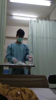 a man in scrubs is preparing to go into an operating room with medical equipment