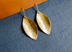 "Gold Leaf Earrings. Hammered brass drops on 14K gold filled ear wires. Simple leaf earrings. Perfect everyday jewelry. Great gift for mom.  Simple everyday earrings that you'll reach for time and again. Small golden vintage brass leaves have been hammered and gently curved to catch the light. Leaves are suspended from high quality 14K gold filled ear wires. Lightweight and easy to wear with any outfit. These earrings hang just over 1 1/4\" (3.5cm) from the top of the ear wire's curve to the bot Brass Earrings Handmade, Simple Leaf, Gold Leaf Earrings, Hammered Brass, Great Gifts For Mom, Everyday Earrings, Brass Jewelry, Brass Earrings, Everyday Jewelry