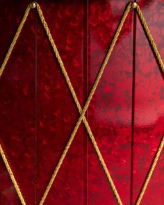 an ornate red cabinet with gold trimmings on the front and side paneling