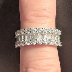 a woman's hand with a diamond ring on top of her finger and an engagement band in the middle