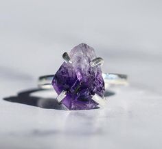 A rough and raw amethyst nugget is framed in a sterling silver 4 prong claw style setting and sit atop a hammered sterling silver band. Light shines though the stone in all directions which allows it to ✨GLOW✨!Genuine 925 stamped sterling silver. ***This listing is for one citrine ring.Stones are about 1/2 inch in size. Please keep in mind that they are natural, so will vary in exact shape, color tone and size. No two are alike, but all are equally beautiful! Every item purchased arrives in a lo Raw Amethyst Ring, Amethyst Wedding Rings, Ring Stones, February Birthstone Ring, Healing Crystal Ring, Amethyst Birthstone, Raw Stone Ring, Raw Amethyst, Rose Quartz Ring