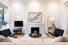 a living room filled with furniture and a fire place in front of a painting on the wall