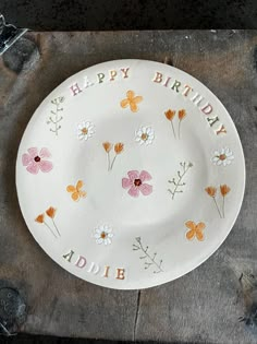 a white plate with flowers and the words happy birthday on it