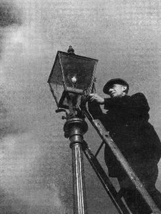 a man standing on top of a metal pole next to a street light under a cloudy sky