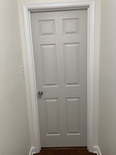 a white door in a room with wood floors