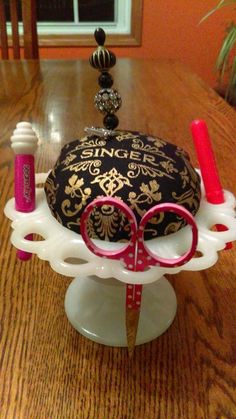 a table topped with a cake covered in scissors and eyeglasses on top of it