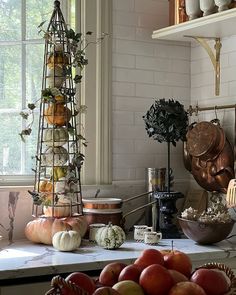 a kitchen counter topped with lots of fruit and veggies next to a window