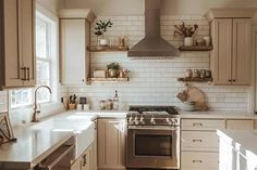 a kitchen with white cabinets and stainless steel stove top oven in the middle of it