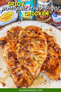 three pieces of pineapple brown sugar chicken on top of a white plate next to cans of sauce