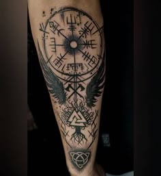 a man's arm with a compass and wings tattoo design on the left forearm